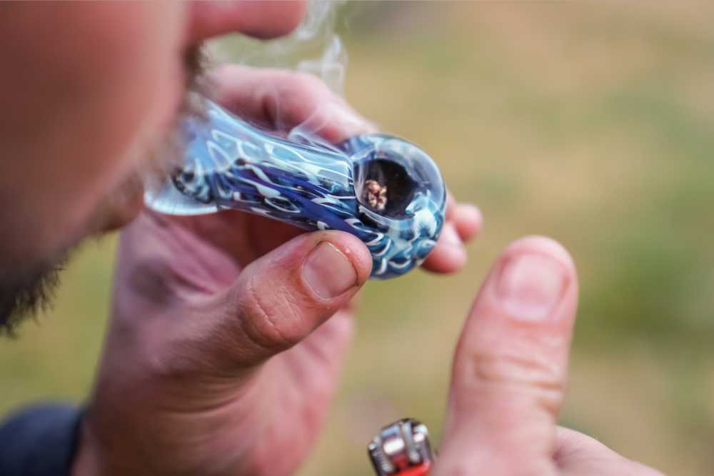 closeup of man smoking from a glass pipe