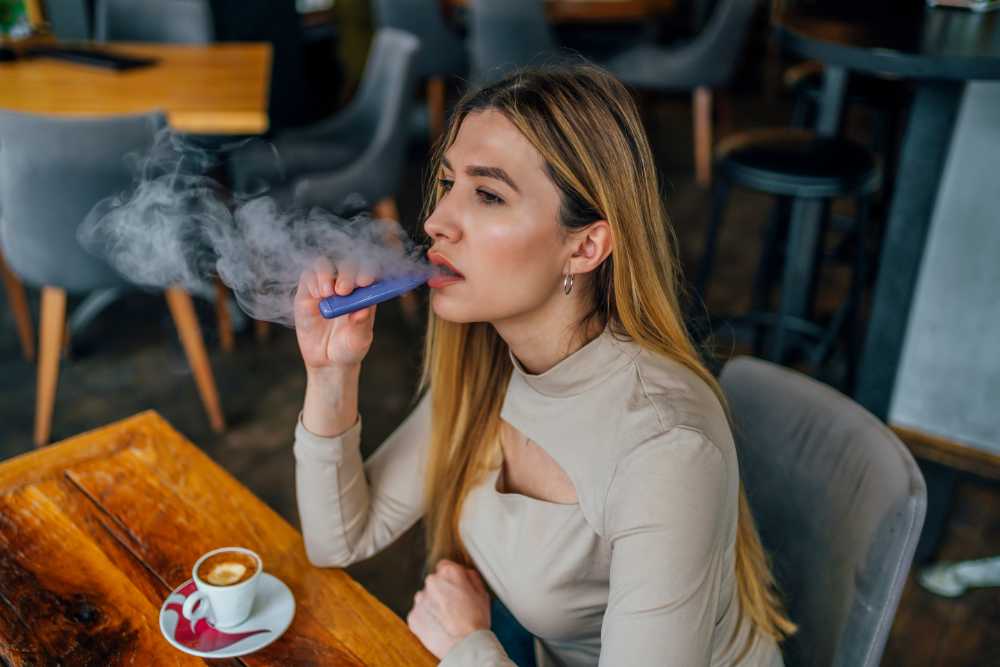 chic-woman-vaping-in-cafe