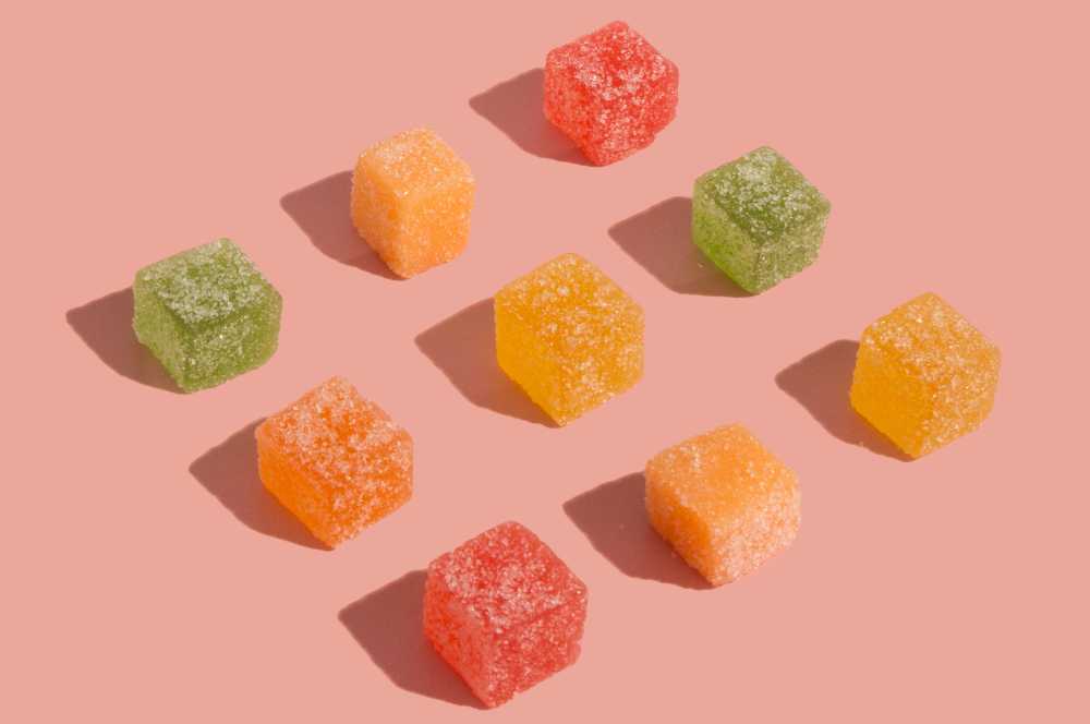 nine gummy cubes on pink table