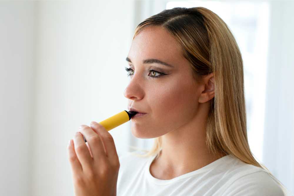 woman taking a hit of a disposable vape