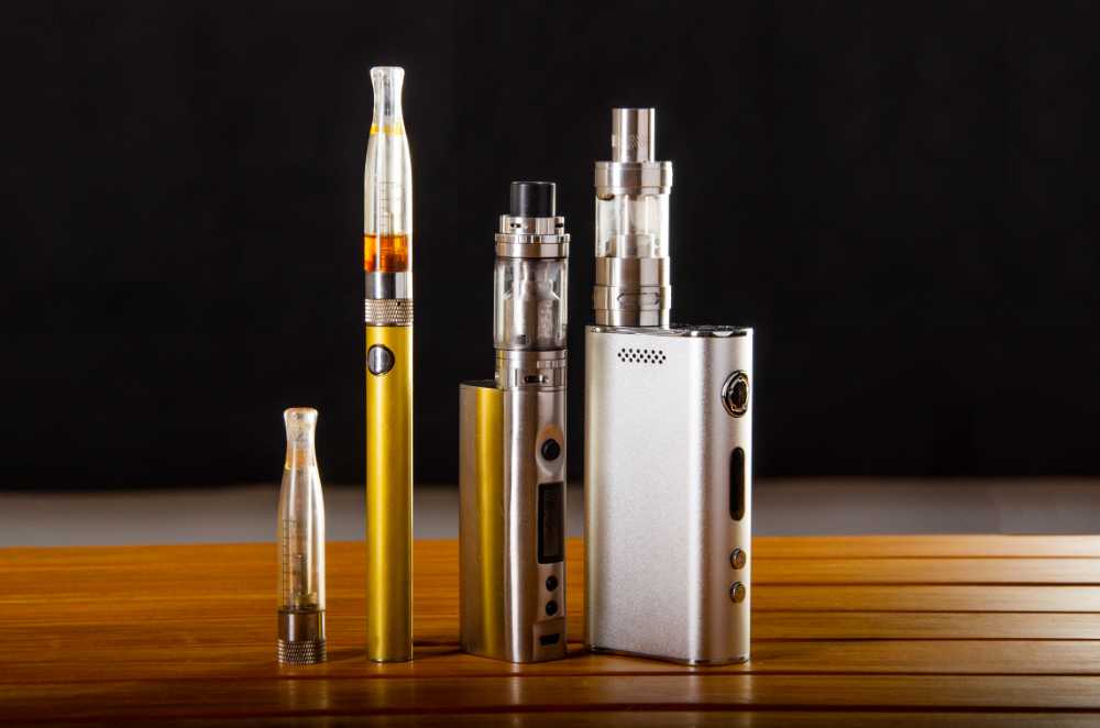 various types of vape carts and batteries upright on wood table