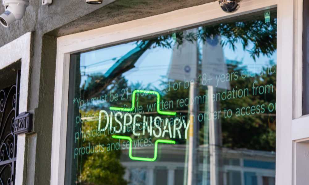 cannabis dispensary neon sign on glass door