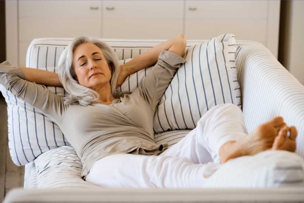 lady with white hair relaxing on white couch