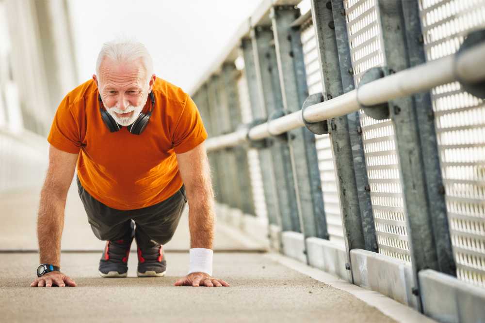 old man wearing orange shirt doing push ups