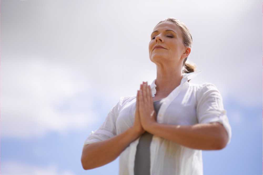 woman outside in prayer pose