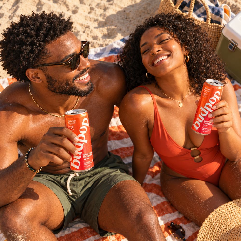 Blood Orange Pomegranate THC Soda black couple at beach smiling drinking budpop blood orange pomegranate thc soda